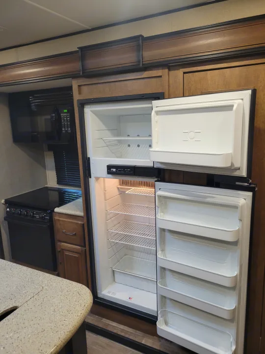 RV rental kitchen: open refrigerator, microwave, stove, and countertops. Ready for your adventure on the road.. Grand Design Reflection 2017
