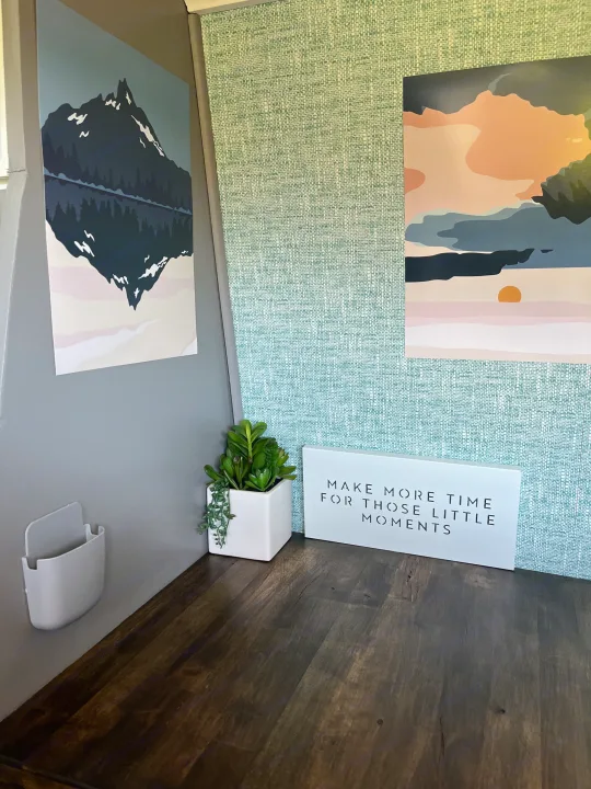 Cozy RV rental interior: mountain & sunset art, textured green wall, white caddy, succulent plant, and inspiring sign.. Mercedes-Benz Sprinter 2013