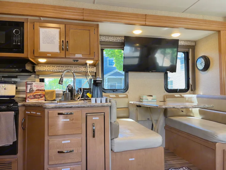 Well-equipped RV rental interior: kitchen with microwave, sink, coffee maker, and comfortable dinette.. Thor A.C.E. 2017