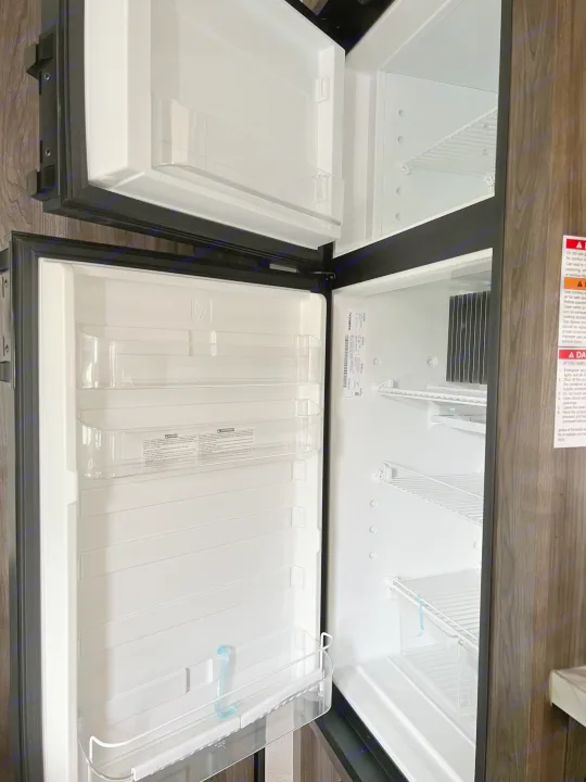 Clean, empty RV refrigerator, perfect for your next rv rental trip. Top freezer, bottom fridge, ready for food.. Highland Ridge RV Open Range 2020