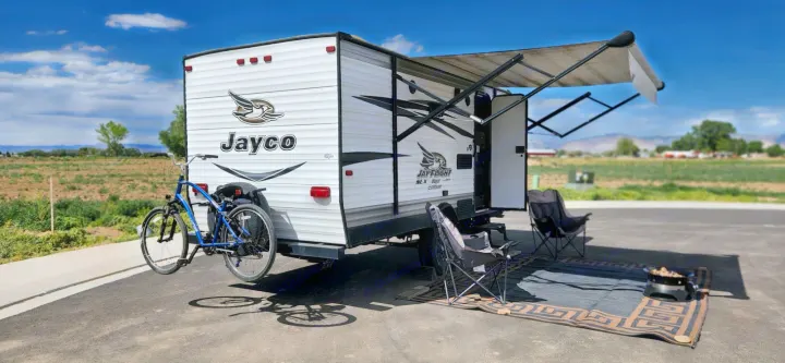 Perfect day for an RV rental adventure! Jayco travel trailer, bike, awning, and camp chairs ready for relaxation.. Jayco Jay Flight SLX 2016