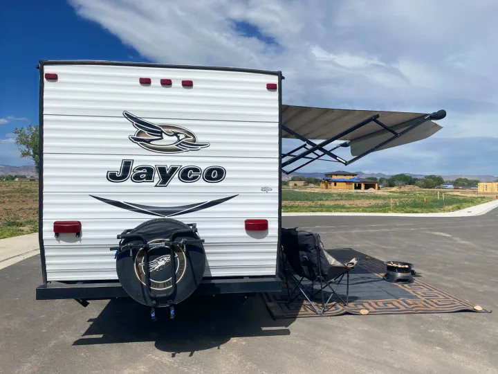 This RV rental is set up with an extended awning, outdoor mat, camping chair, and portable fire pit for relaxing.. Jayco Jay Flight SLX 2016