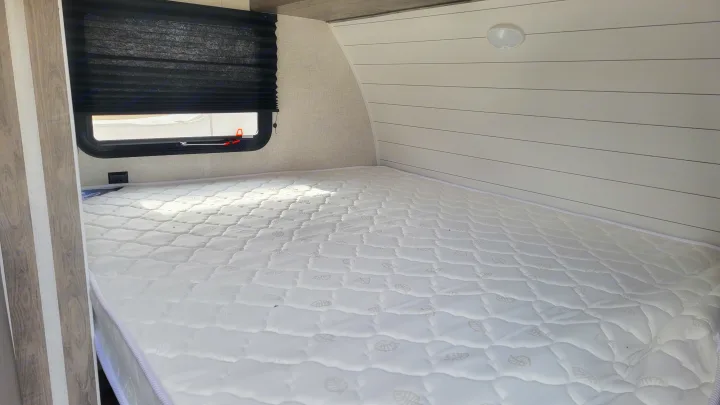 RV rental: Bright bedroom interior with a white patterned mattress, window, and modern paneling. Ready for your trip.. Forest River EVO 2021