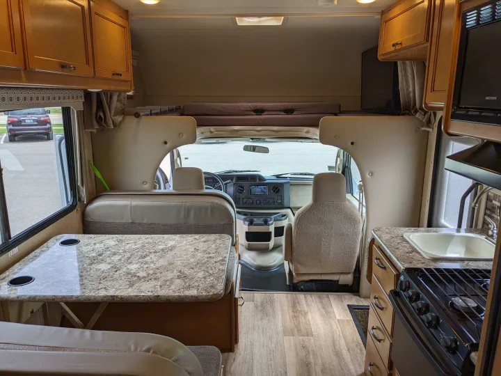 Spacious RV rental interior featuring a cozy dining area, fully equipped kitchen, and driver's cabin.. Thor Motor Coach Four Winds 2017