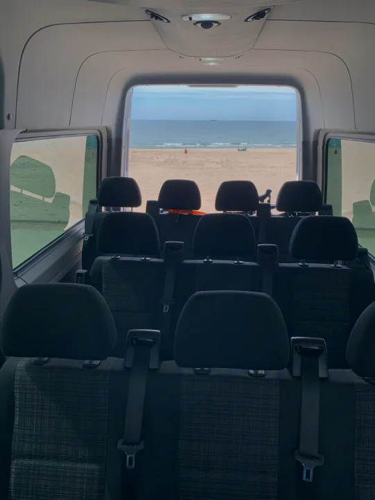 Inside RV rental: Comfortable back seats offer a direct view of a sandy beach and ocean, with a ship in the distance.. Mercedes Benz 2017 Sprinter Van 2017