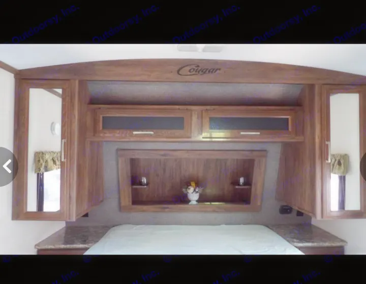 RV rental bedroom: Compact, featuring a bed, wooden overhead cabinets, mirrored closets, and built-in storage.. Keystone RV Cougar X-Lite 2015