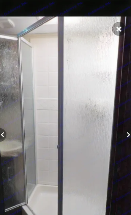 RV rental: Step inside this compact RV shower with textured glass doors, white tiled walls, and a clean shower pan.. Keystone RV Cougar X-Lite 2015