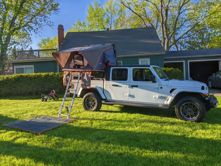 Setup for adventure: White Jeep Gladiator with a rooftop tent & ladder on a green lawn. Consider this unique rv rental for camping.. Jeep gladiator overland Jeep gladiator overland 2020