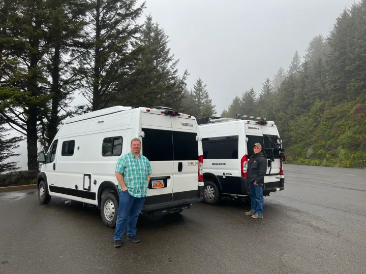 Two men with their RV rentals, a Winnebago Solis and Thor Sequence, parked in a foggy forest setting.. Winnebago Solis 2022