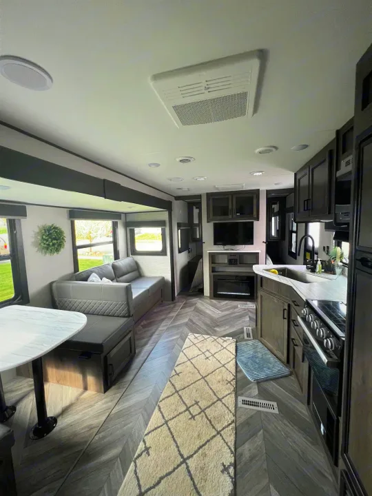 Spacious, modern RV rental interior featuring a living area, kitchen, and dining space. Perfect for comfortable travel.. Highland Ridge Open Range Olympia 2022