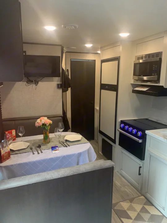 Cozy RV rental interior featuring a set dining table, kitchen appliances, and entertainment area. Perfect for travel.. Jayco Jay Flight 2022