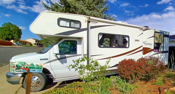 White Coachmen Freelander RV rental/motorhome parked roadside in a sunny neighborhood, ready for travel.. Coachmen Freelander 2011