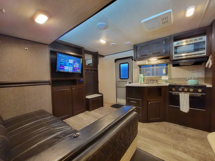 Cozy RV rental interior featuring a living area with TV and a fully equipped kitchen, perfect for travel.. Heartland RVs Pioneer 2019