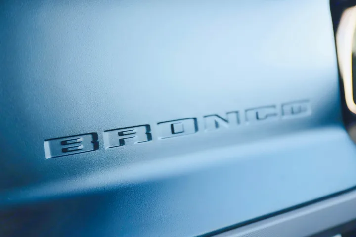 Embossed 'BRONCO' detail on a matte blue vehicle surface, perfect for your next RV rental trip.. Ford Bronco 2024