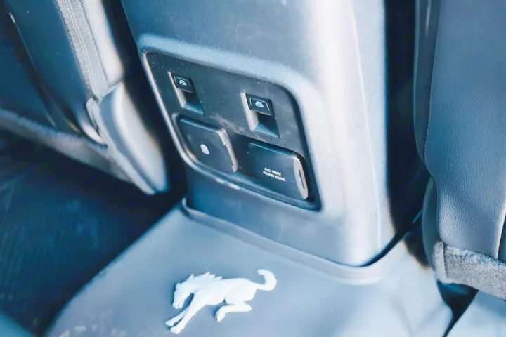 Back seat convenience in this RV rental: power window controls, AC 110V outlet for charging devices, and a cool Bronco logo.. Ford Bronco 2024