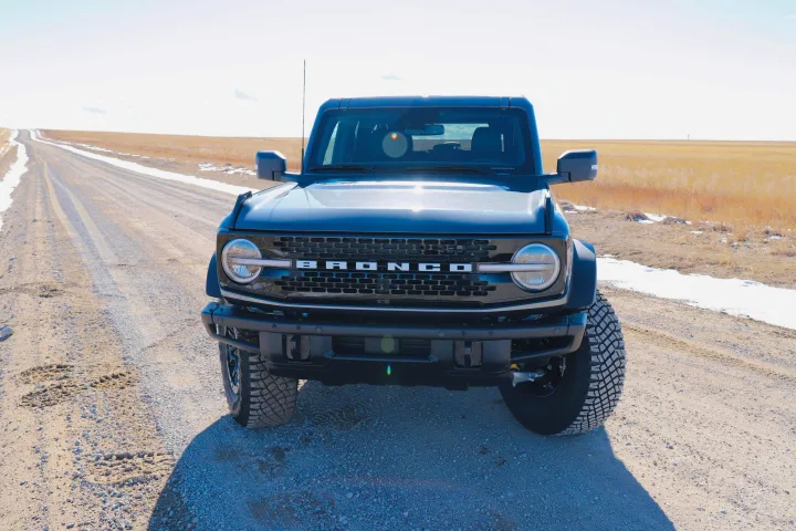 A black Ford Bronco SUV on a snowy gravel road, ready for adventure. A rugged alternative to an RV rental.. Ford Bronco 2024