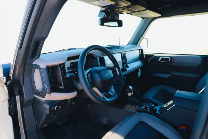 Interior of a Ford Bronco, showcasing its modern dash, steering wheel, and seats. A great option for adventures, even without an RV rental.. Ford Bronco 2024