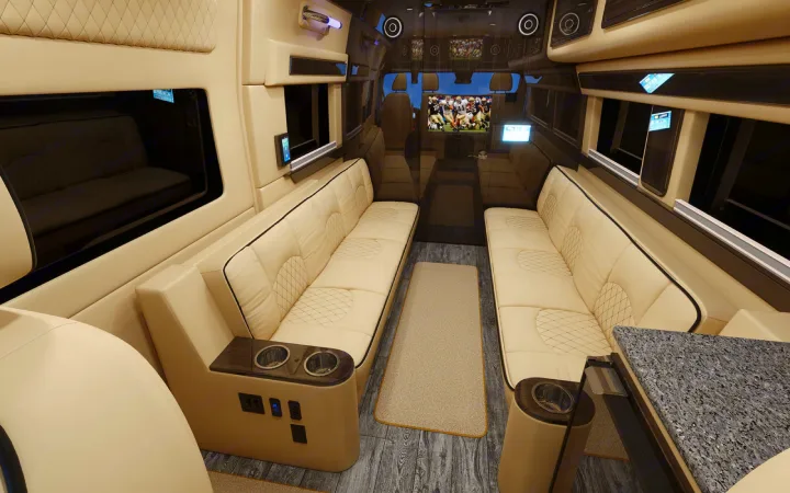 Inside a premium rv rental: plush cream seating, wood floors, and entertainment screen for ultimate comfort on the go.. Ultimate Toys Ultimate Camper 2023