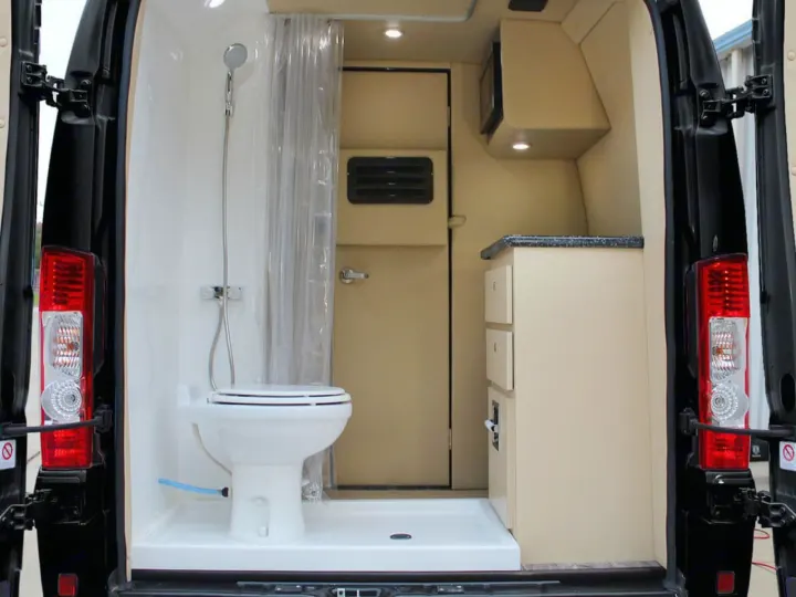 Compact rv rental van interior features a wet bath with toilet and shower, plus a functional kitchen with cabinets.. Ultimate Toys Ultimate Camper 2023