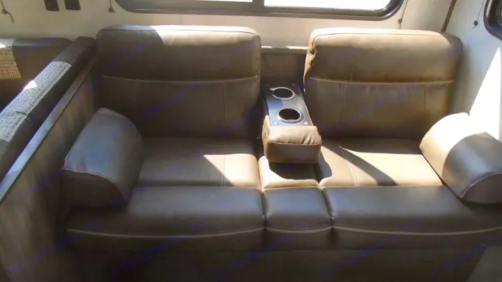 Comfortable brown seating with built-in cup holders inside this RV rental, offering relaxation for your journey.. Crossroads RV Zinger 2022