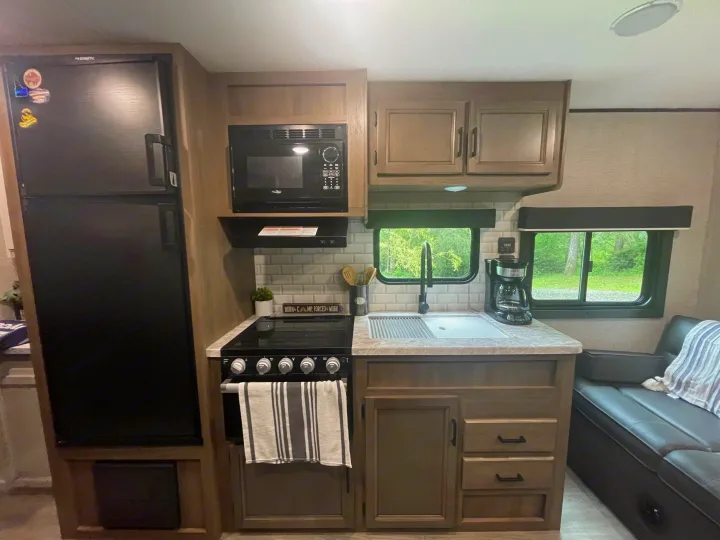 Explore this functional RV rental kitchen, equipped with a fridge, microwave, stove, sink, and coffee maker.. Jayco Jay Flight 2022