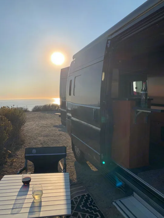Enjoying a stunning sunset ocean view from our cozy RV rental. Perfect van life evening with wine.. Roadtrek Roadtrek Class B 2018