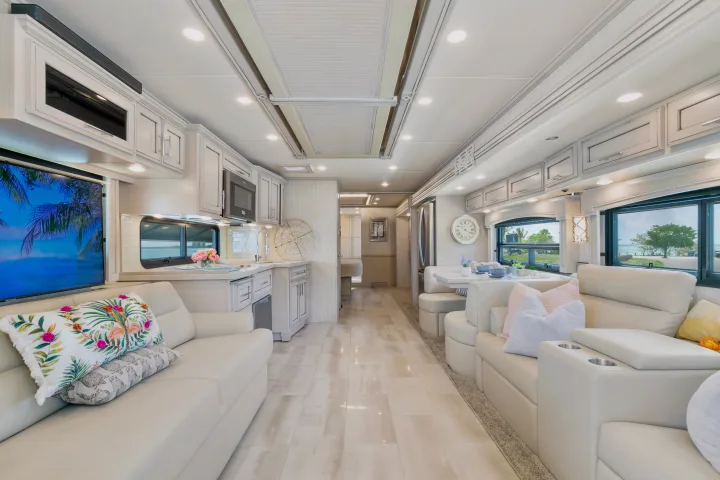 Bright & spacious luxury RV rental interior features modern kitchen, comfy seating, and large windows with scenic views.. Ventana Ventana Motorhome 2022