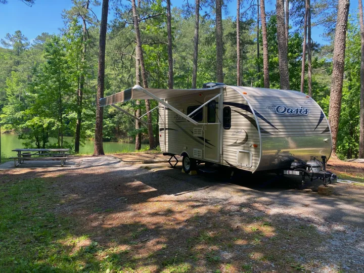RV rental at a peaceful lakeside campsite with tall trees & picnic table. Perfect for nature lovers!. Shasta Oasis 18BH 2018