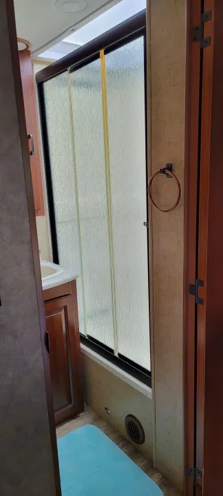 Inside an RV rental: view of ceiling skylight, air vent, and wooden cabinets from below.. Forest River 3171DS 2016
