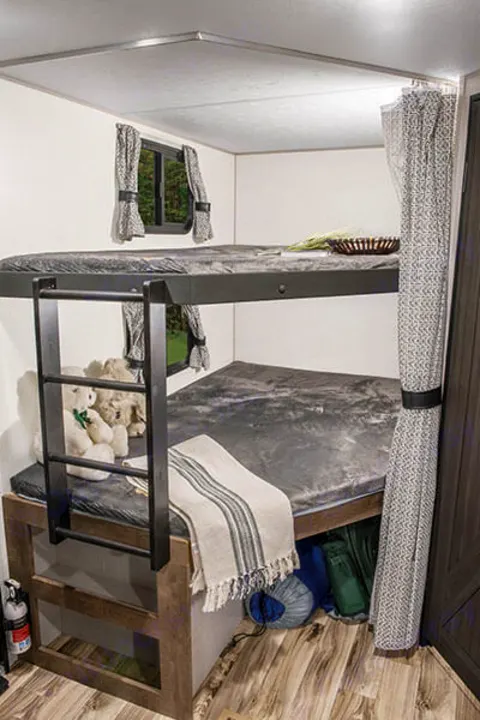 Cozy RV rental interior: bunk beds with ladder, windows, and storage, creating a practical family sleeping area.. Venture Stratus VBH261 2022