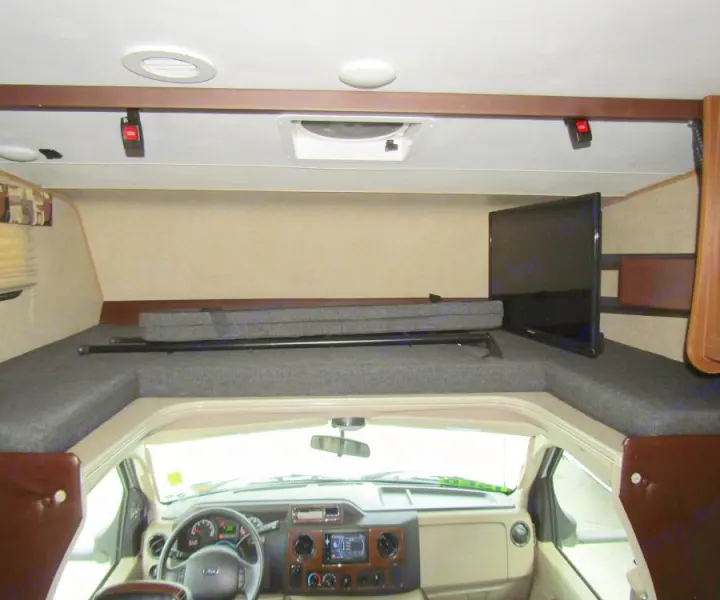 RV rental interior: Overhead bunk bed with TV above driver's cab. Spacious and cozy for travel.. Coachmen Leprechaun 2017