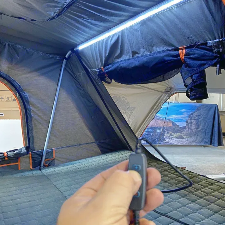 User controls bright LED lighting inside a rooftop tent setup, perfect for an RV rental camping trip.. Toyota Tundra 2011