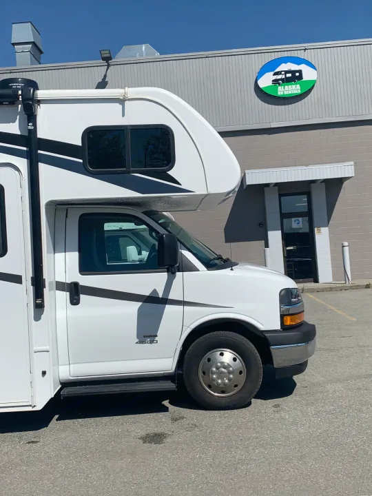 A white motorhome RV rental is parked at the Alaska RV Rentals building under a sunny sky.. Forest River Forester 2551DSLE 2021