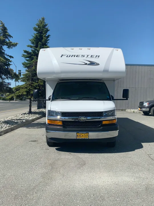Front view of a white Forester RV rental, an Alaska motorhome with plate KHG 165, parked outdoors.. Forest River Forester 2551DSLE 2021