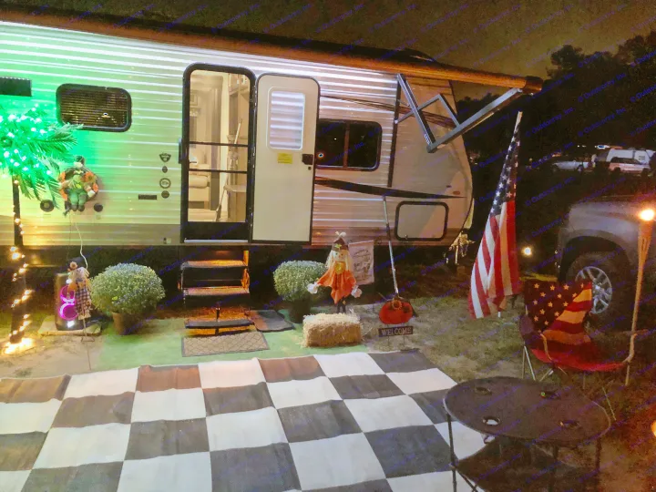 Experience the charm of an RV rental campsite at night, adorned with green lights, fall decor, and patriotic touches.. Jayco Flight 2019