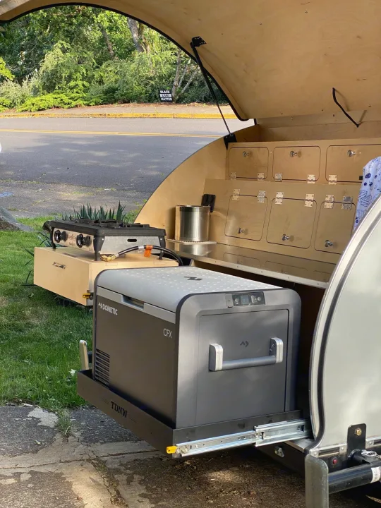 Teardrop RV rental: Rear galley kitchen setup with slide-out Dometic fridge and Camp Chef stove.. Teardrops Northwest Trek 2022