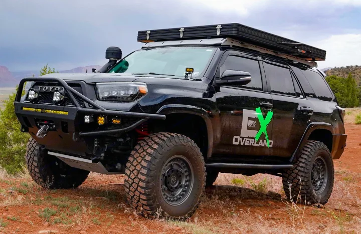 Black overlanding 4Runner with roof tent on dirt. Great adventure vehicle, consider this unique RV rental option!. Toyota 4Runner 2013