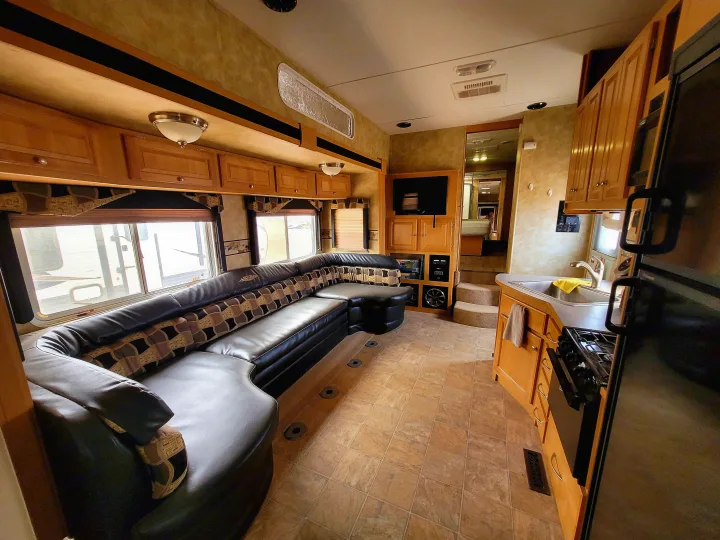 Explore this RV rental's spacious interior: large U-shaped sofa, full kitchen, and entertainment center for your travels.. Heartland Cyclone 2009
