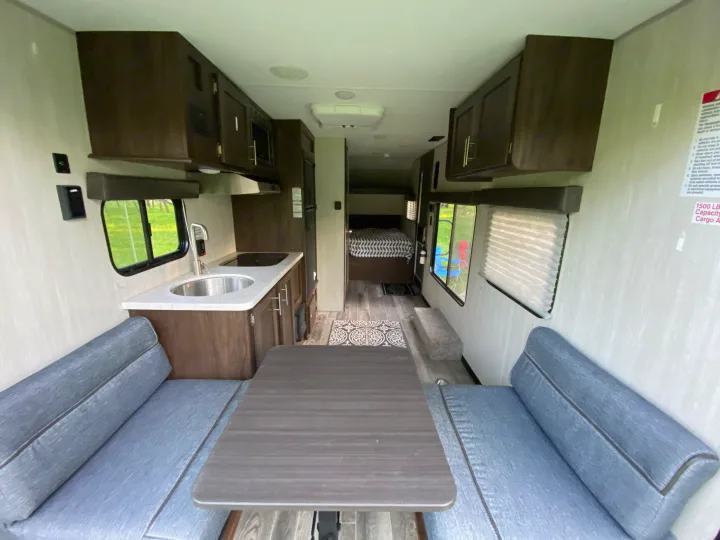 Modern RV rental interior with dining, kitchen, and bedroom areas visible, perfect for travel.. Forest River Cherokee Wolf Pup 2019