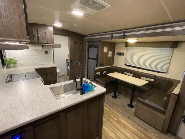 Cozy RV rental interior: well-appointed kitchen with sink & stove, plus a comfy dinette. Ready for your road trip adventures!. Cruiser RV MPG Ultra Lite 2019
