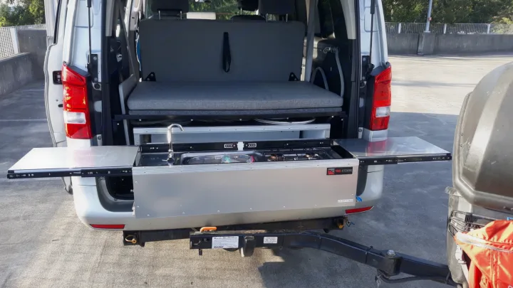 Outdoor cooking setup in an RV rental: This camper van features a slide-out kitchen with a sink and stove for convenient outdoor meals.. Mercedes Metris 2016