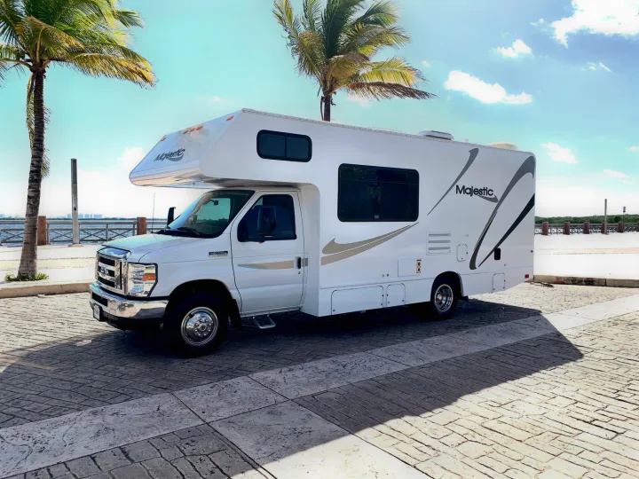 Majestic RV rental parked by palm trees & water on a sunny day. Ideal for your next outdoor travel adventure.. THOR MAJESTIC 23a 2018