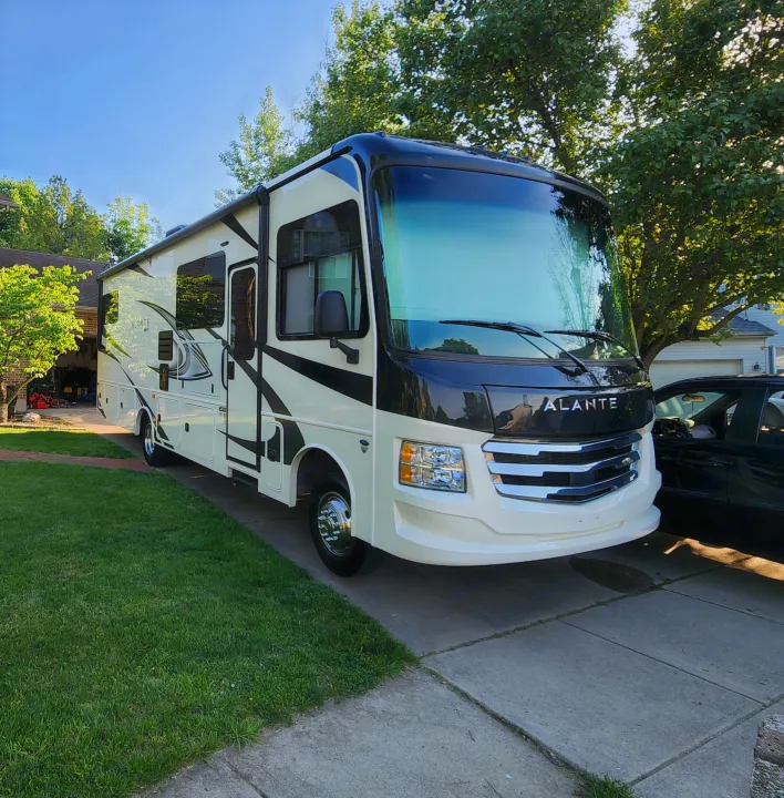 A modern, white & black Alante RV, perfect for rv rental, is parked in a driveway on a sunny day.. Jayco Alante 2022