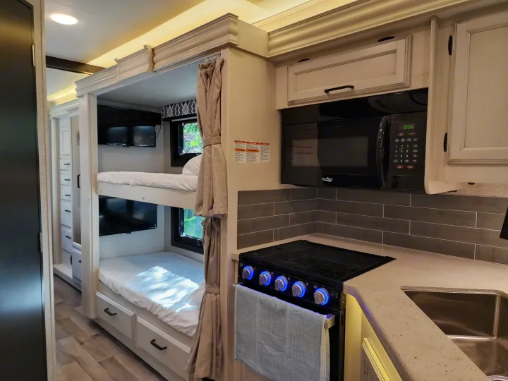 Compact and modern **RV rental** features a full kitchen with microwave, stove, sink, plus comfortable bunk beds.. Jayco Alante 2022