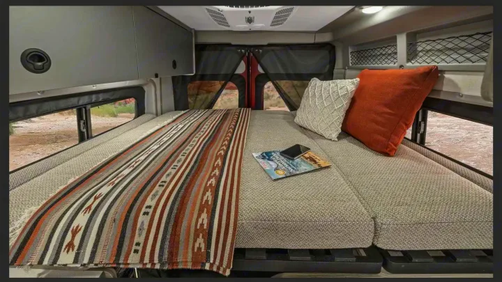 Cozy camper van RV rental bed with scenic view for mobile travel adventures.. Winnebago pocket 2023