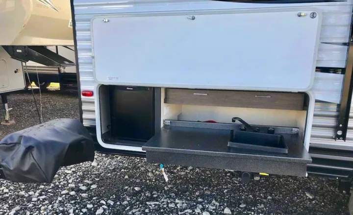 This RV rental features a convenient outdoor kitchen with a built-in fridge, sink, and counter for easy camping meals.. Forest River Salem Cruise Lite 2018