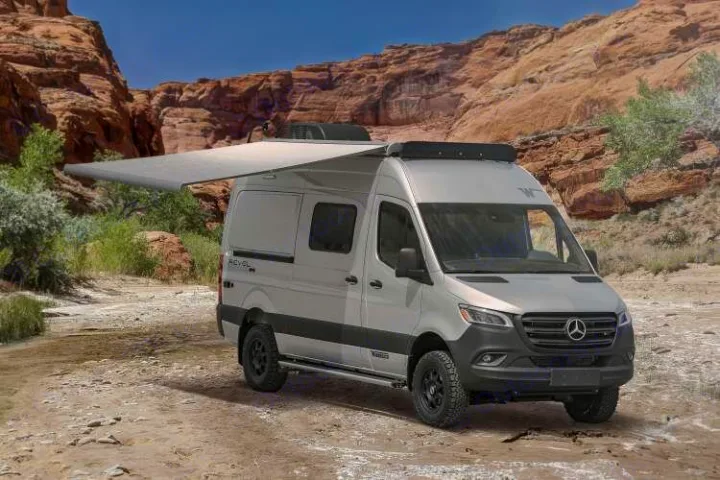 Silver Winnebago Revel camper van with awning extended in a scenic desert. Your next RV rental adventure awaits!. Winnebago Revel 2022
