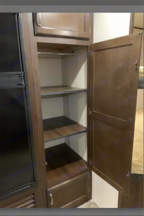 RV rental interior featuring a versatile storage cabinet with shelves, hanging rod, and drawer, next to a refrigerator.. Jayco Jay Flight SLX Baja Edition 2017