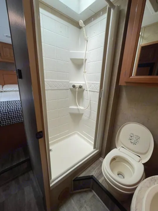 Discover the clean and compact RV rental bathroom, featuring a stand-up shower and toilet for convenient travel.. Sunseeker 2650 2015