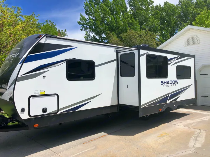 White Shadow Cruiser RV rental with blue accents, parked on a sunny driveway. Ready for adventure!. Cruiser Rv Corp Shadow Cruiser 2021